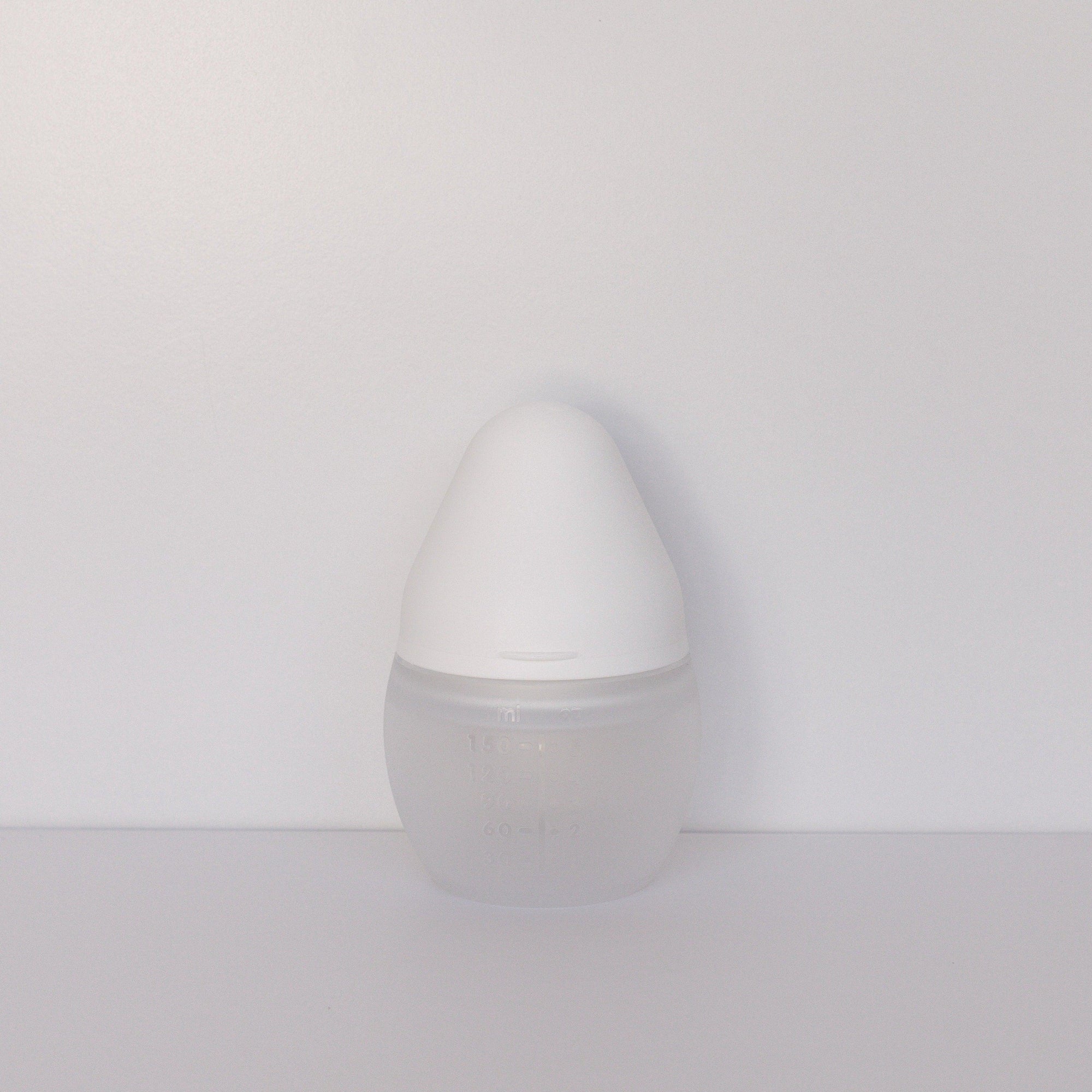 A milk BibRond bottle by Elhée France standing against a white surface.